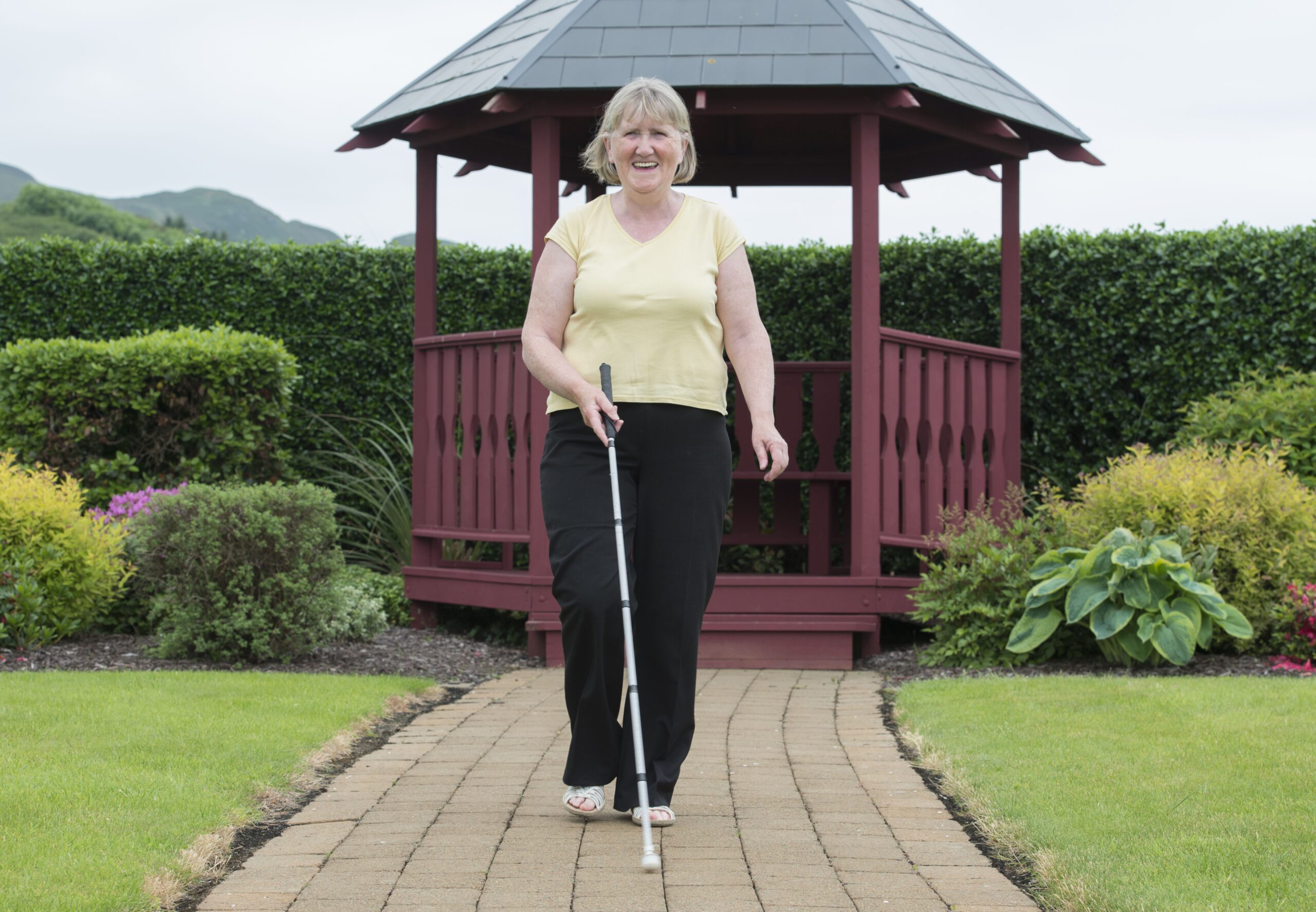 Image of Margaret walking with her cane