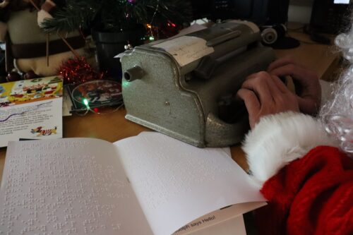 Photo os Vision Ireland Santa writing a letter in braille