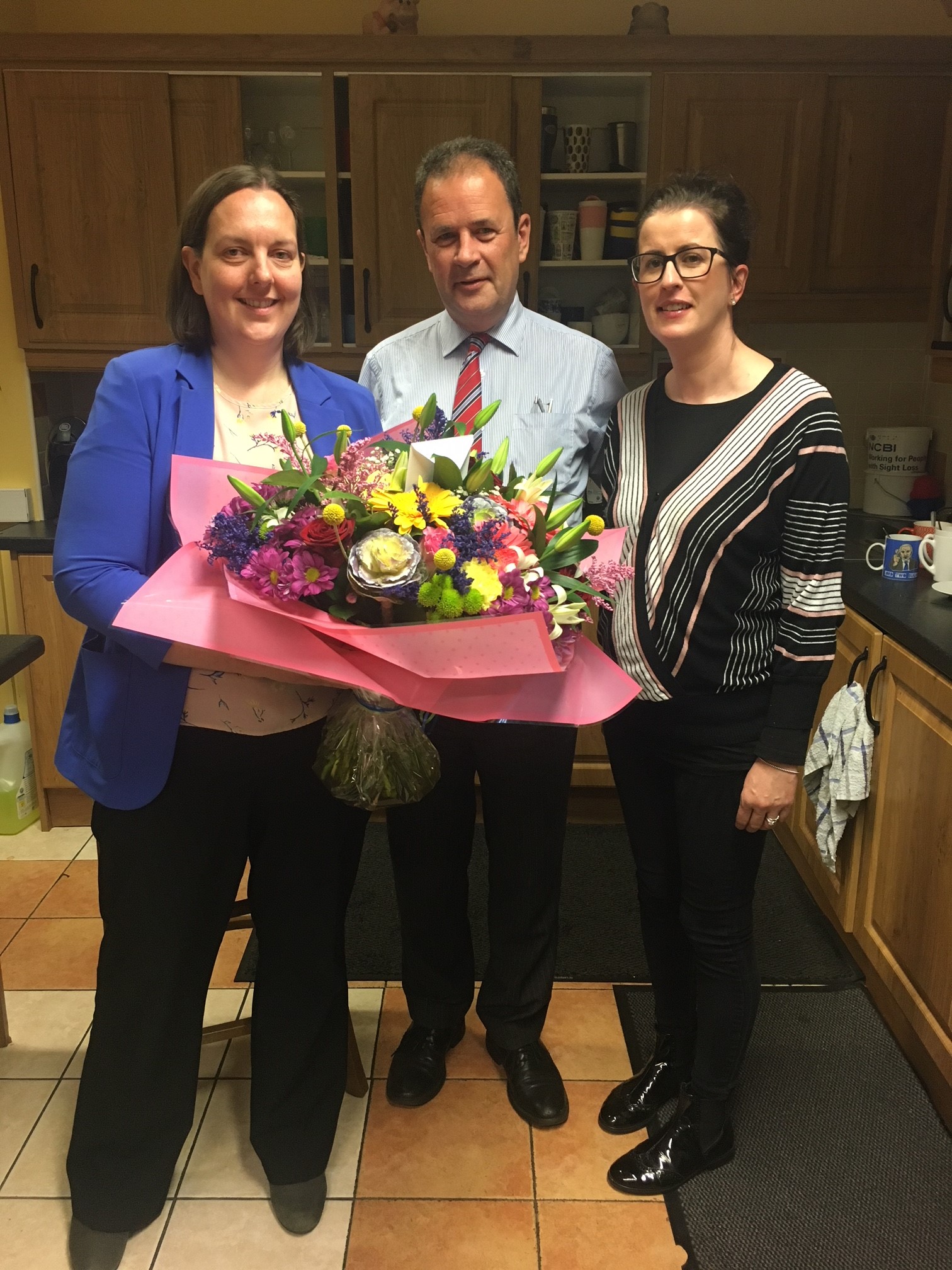 Image of Fionnuala, Ruairi and Niamh Connolly with flowers