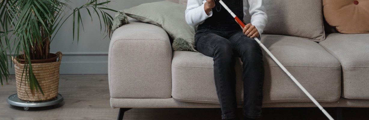 person with a cane sitting on a sofa
