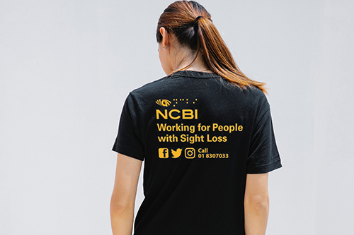 woman in an ncbi t-shirt with their back to you