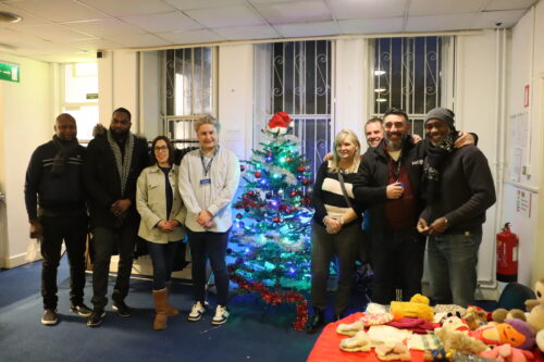 Vision Ireland Retail staff alongside members of staff at Depaul's housing facility in north inner-city Dublin who worked together at the Vision Ireland Retail pop-up store providing free clothing to Depaul service users on Wednesday 14th December. The group are all standing beside a Christmas tree and a clothing rail.